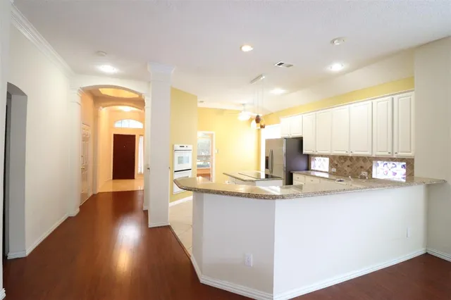 a view of a kitchen with kitchen island a sink appliances