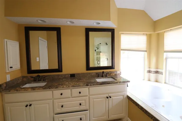 a bathroom with mirror sink and window