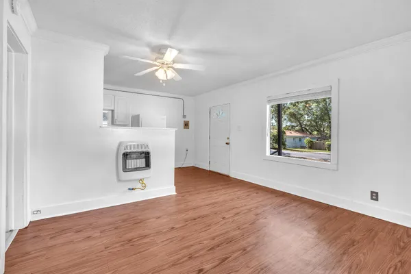 a view of empty room with wooden floor and ceiling fan
