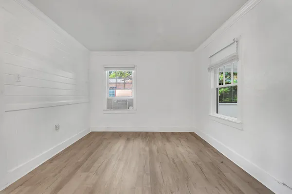 a view of an empty room with wooden floor