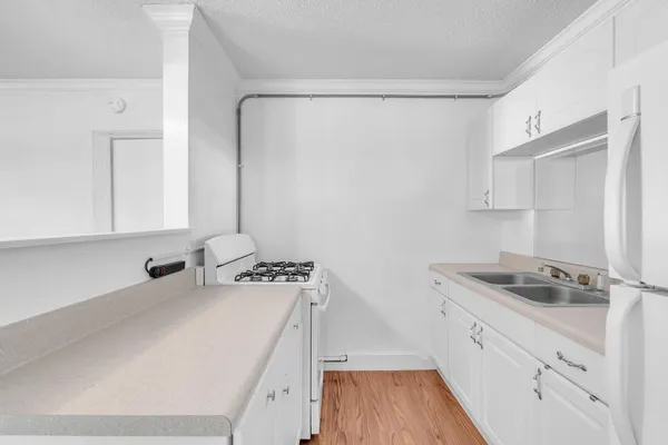 a kitchen with white cabinets and stove
