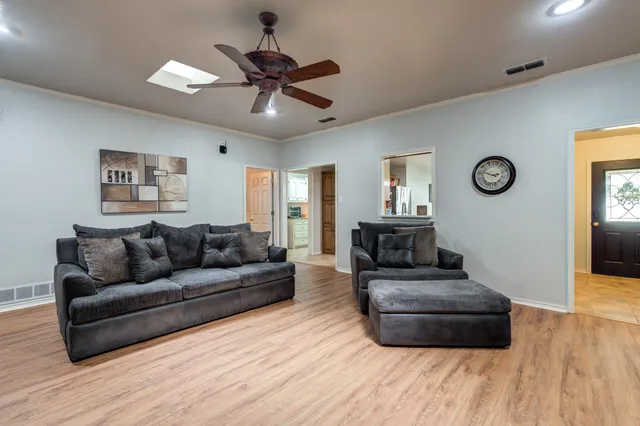 a kitchen with stainless steel appliances granite countertop a stove top oven a sink dishwasher a dining table and chairs with wooden cabinets