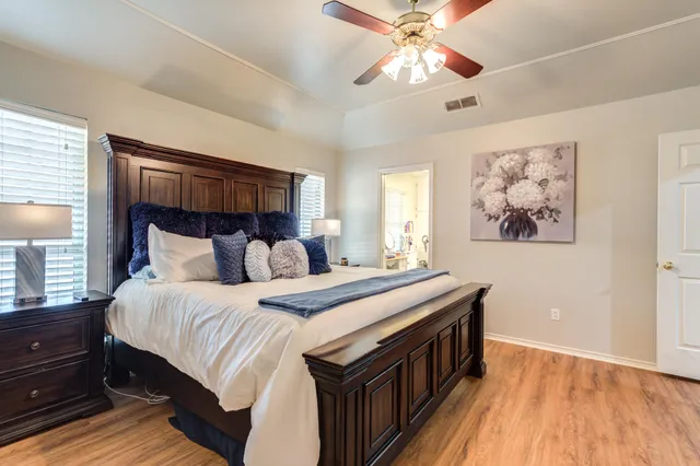 a bedroom with a large bed and a chandelier