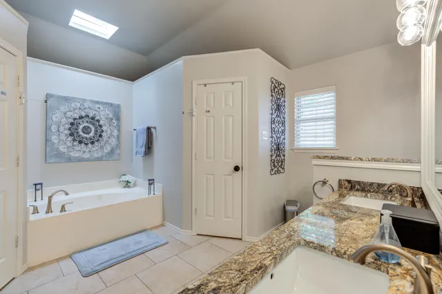 a spacious bedroom with a bed and a chandelier