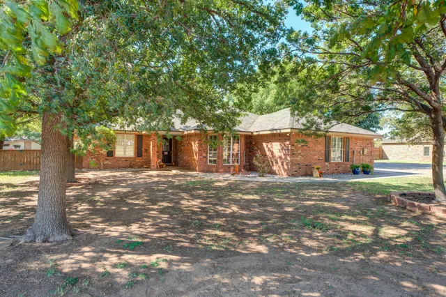 a view of a house with backyard and a tree