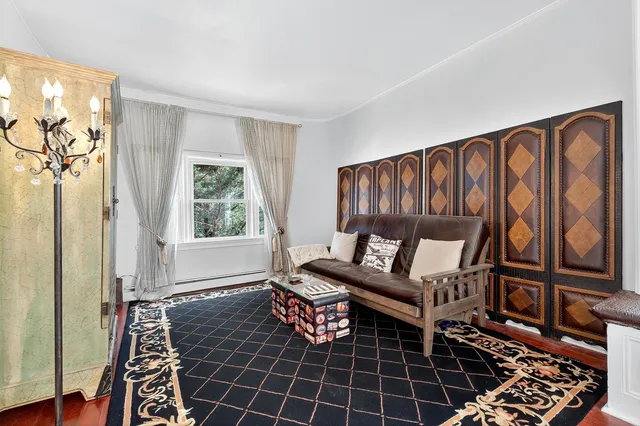 a living room with furniture a rug and a window