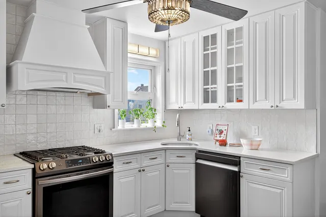 a kitchen with cabinets appliances a sink and a window