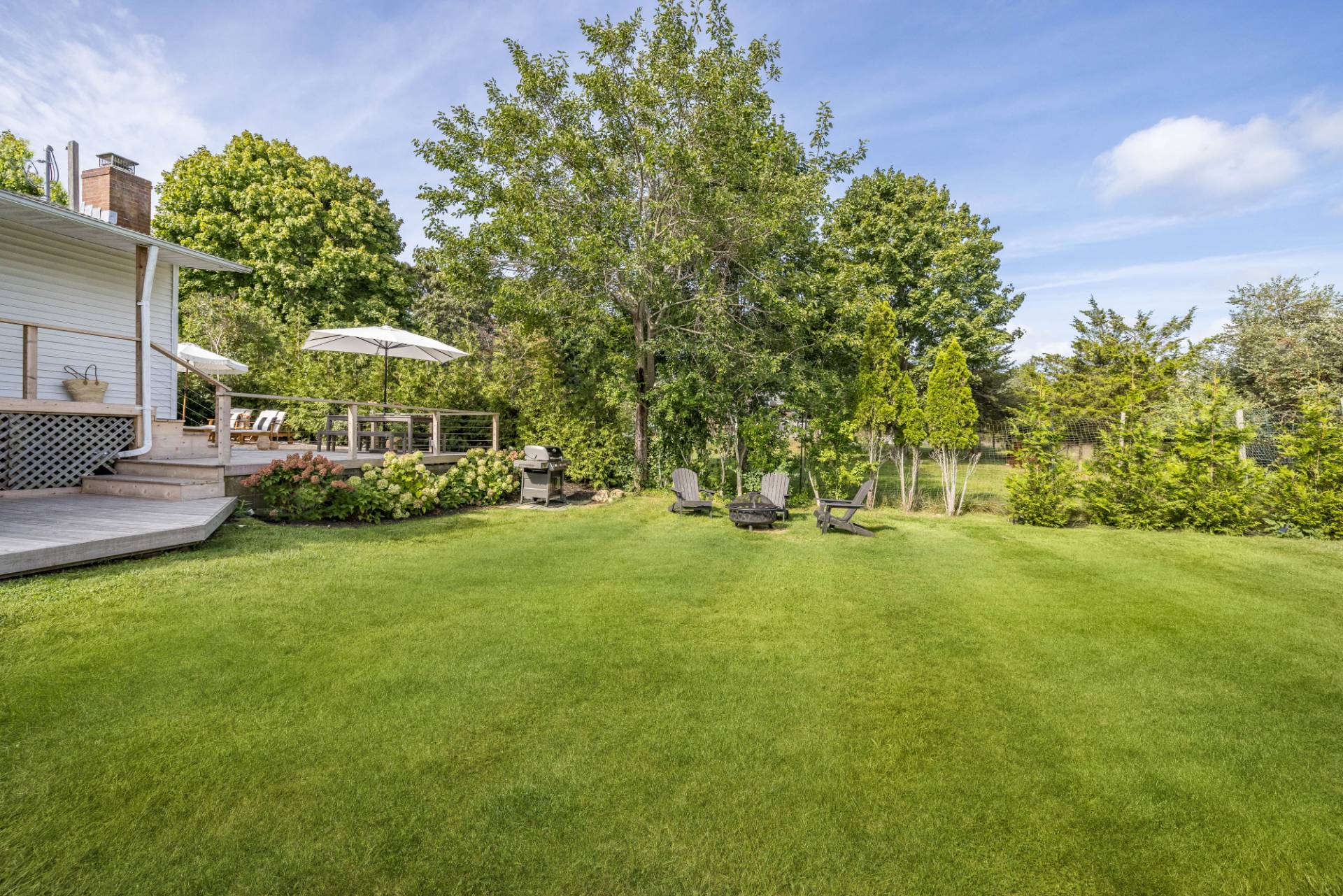 21 Thistle Patch Lane Sag Harbor, NY 11963 - Photo 14 of 17 a view of a patio with table and chairs under an umbrella