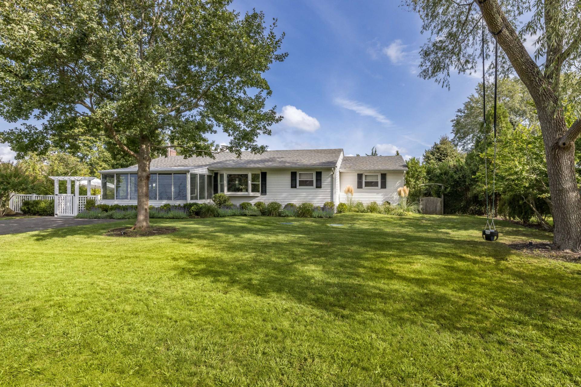 21 Thistle Patch Lane Sag Harbor, NY 11963 - Photo 15 of 17 a front view of a house with a yard table and chairs