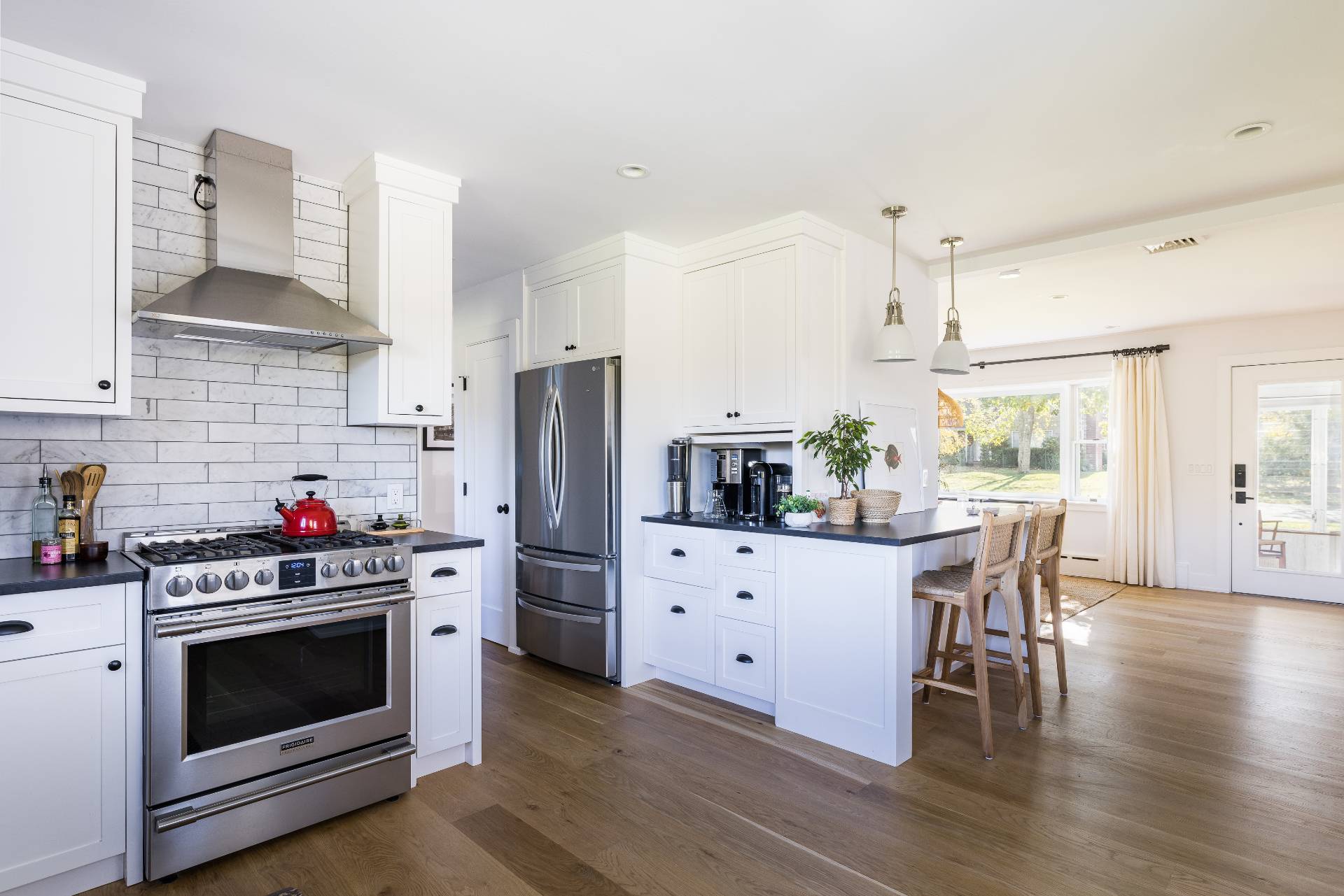 21 Thistle Patch Lane Sag Harbor, NY 11963 - Photo 4 of 17 a kitchen with stainless steel appliances a stove a sink dishwasher a refrigerator white cabinets and wooden floor