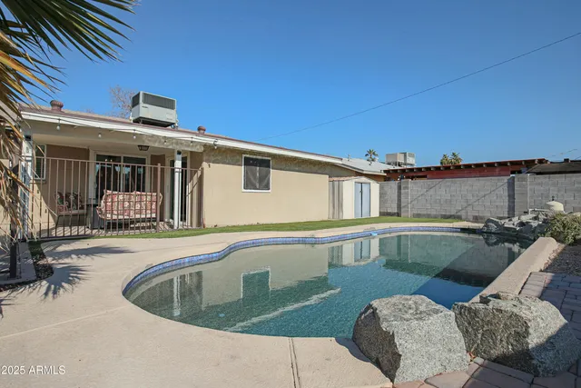 a view of a house with pool and chairs