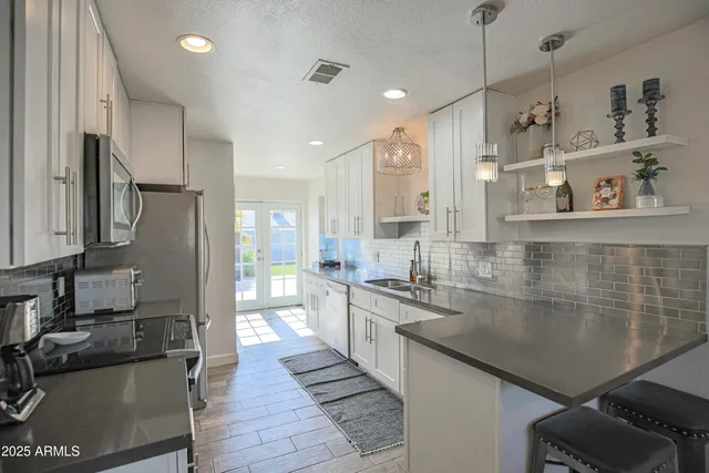 a kitchen with stainless steel appliances granite countertop a sink stove and refrigerator