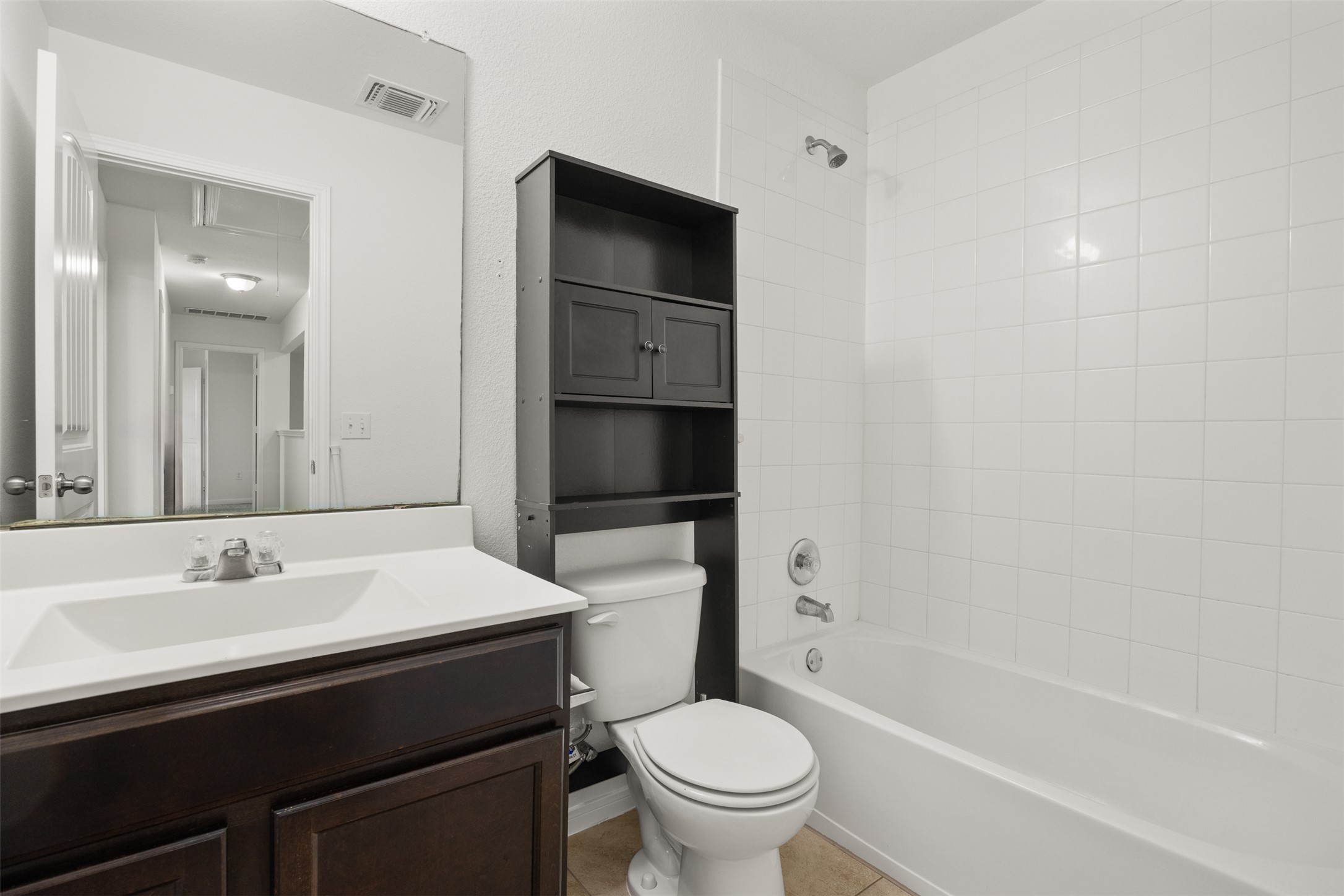 703 Liard River Road Hutto, TX 78634 - Photo 11 of 16 A compact bathroom offers a vanity with ample counter space and an adjacent shower-tub combination.