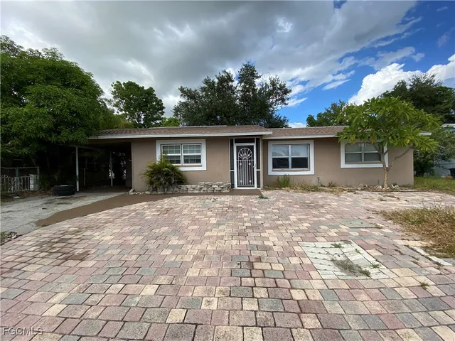 a front view of house with yard and trees around
