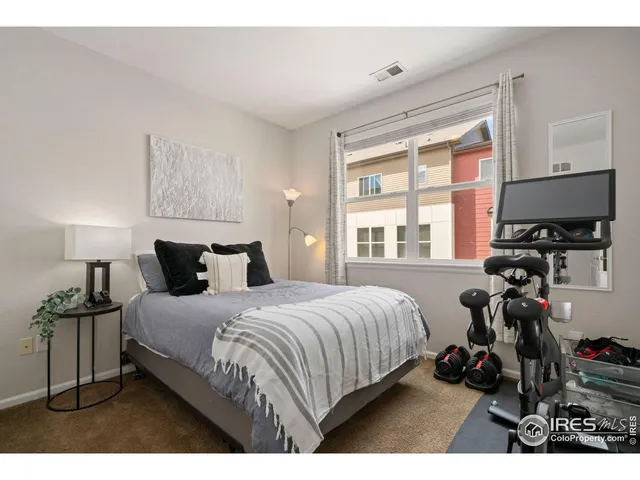 a bedroom with a bed a dresser and a window