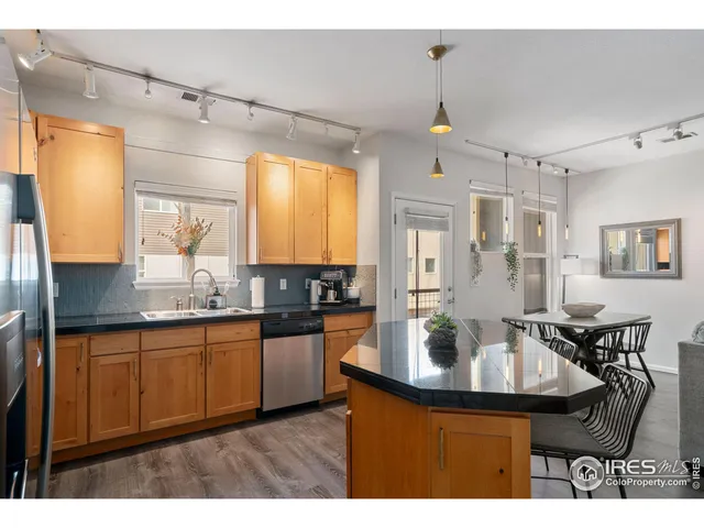 a kitchen with kitchen island granite countertop a sink cabinets and wooden floor
