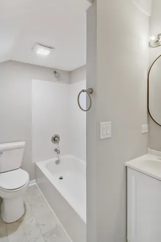 a white toilet sitting next to a bathroom sink