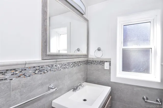 a bathroom with a sink a window and mirror