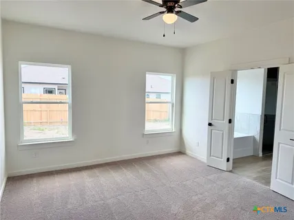 an empty room with a window and a fan