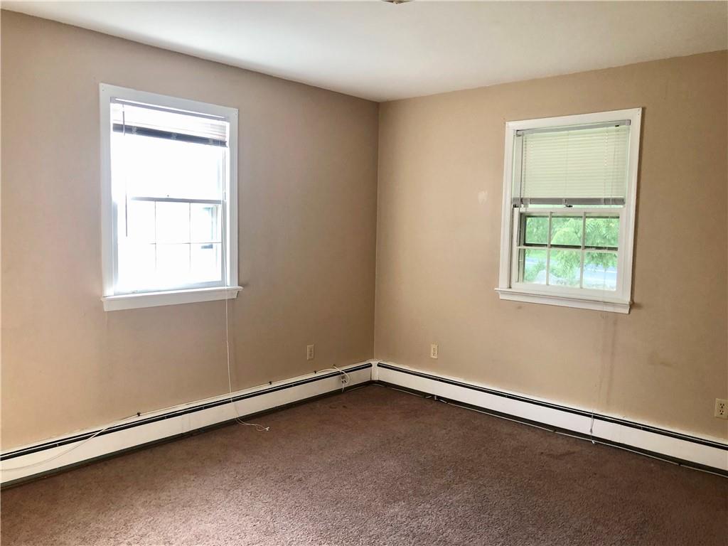 236 Creek Road Poughkeepsie, NY 12601 - Photo 14 of 18 Empty room featuring a healthy amount of sunlight and dark carpet