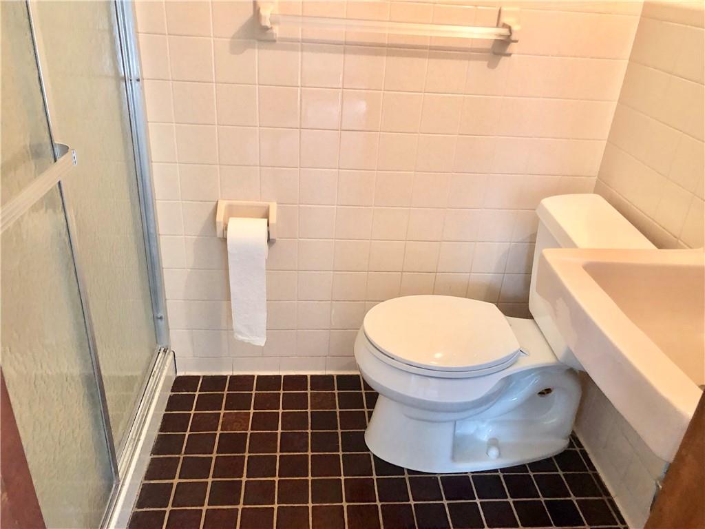 236 Creek Road Poughkeepsie, NY 12601 - Photo 15 of 18 Bathroom with toilet, a shower with door, tile patterned flooring, and tile walls