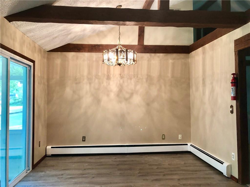236 Creek Road Poughkeepsie, NY 12601 - Photo 6 of 18 Unfurnished room with an inviting chandelier, a textured ceiling, lofted ceiling with beams, and hardwood / wood-style floors