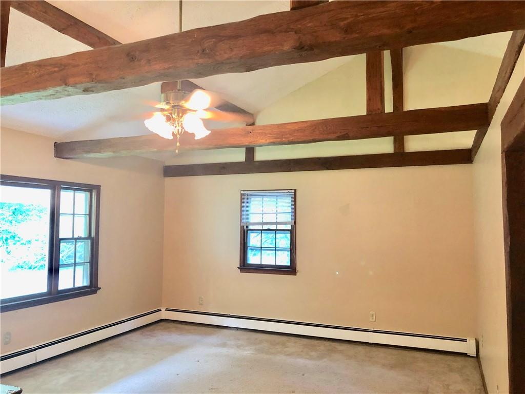 236 Creek Road Poughkeepsie, NY 12601 - Photo 8 of 18 Empty room featuring plenty of natural light, concrete flooring, ceiling fan, and a baseboard heating unit