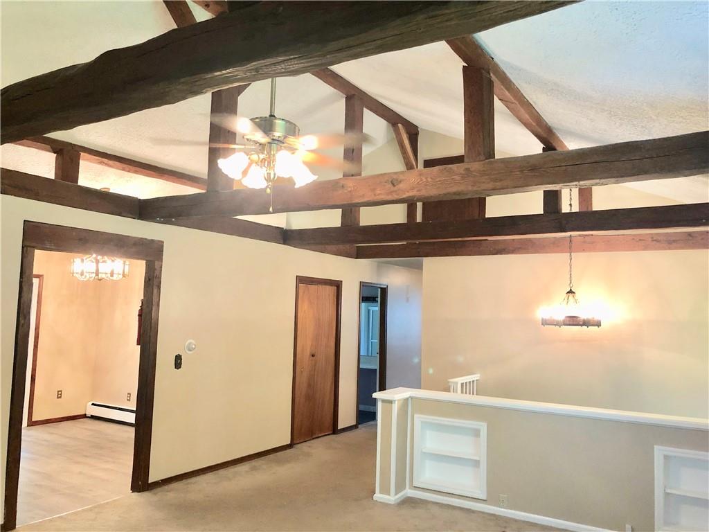 236 Creek Road Poughkeepsie, NY 12601 - Photo 9 of 18 Carpeted empty room with ceiling fan with notable chandelier, baseboard heating, and lofted ceiling with beams
