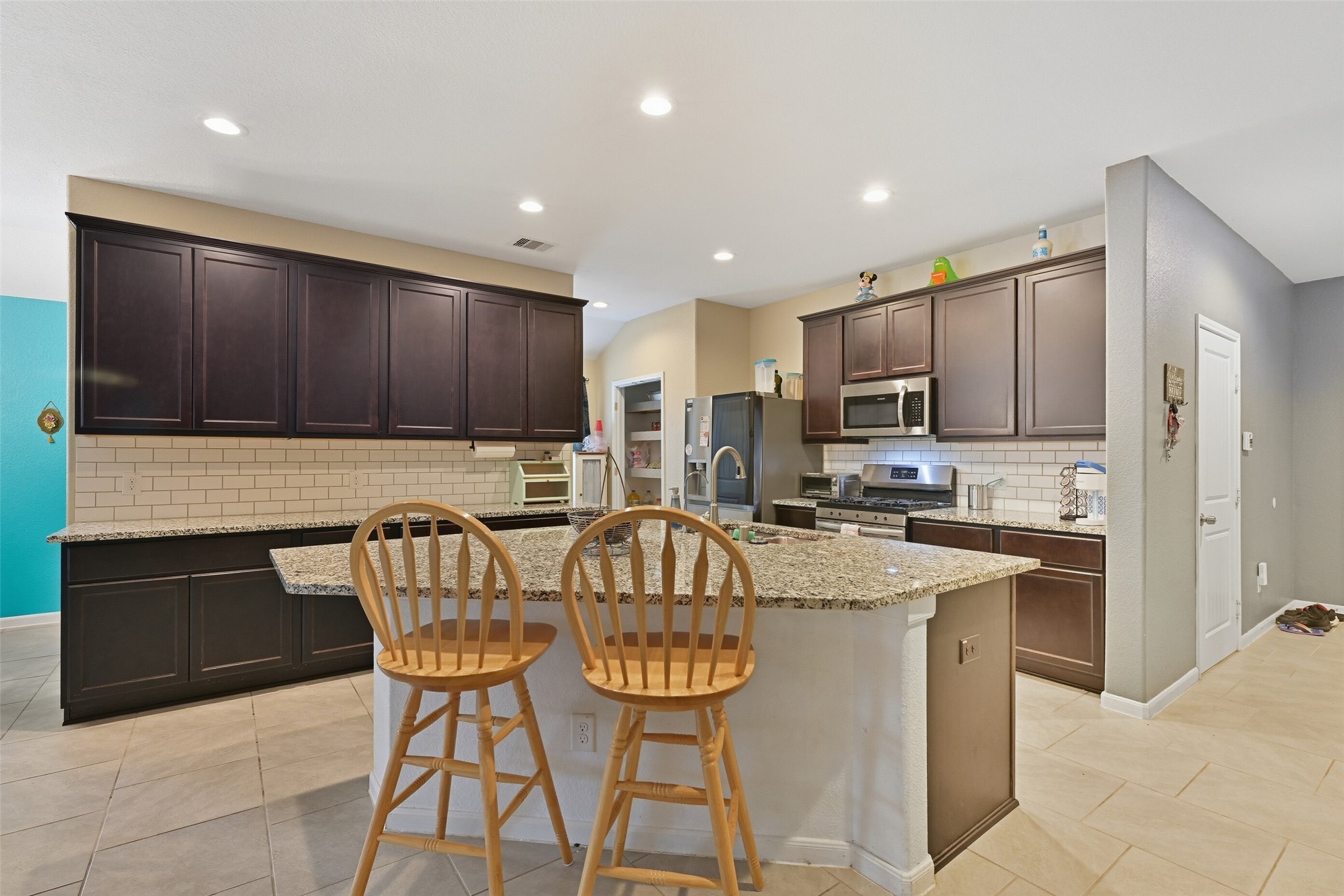 714 Calm Court Rosharon, TX 77583 - Photo 5 of 33 Additional kitchen angle showing ample counter space, built-in microwave, and open flow to the living and dining areas.