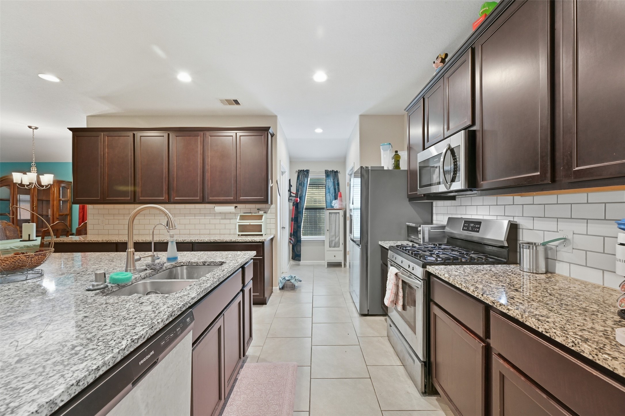 714 Calm Court Rosharon, TX 77583 - Photo 7 of 33 Additional kitchen angle showing ample counter space, built-in microwave, and open flow to the living and dining areas.