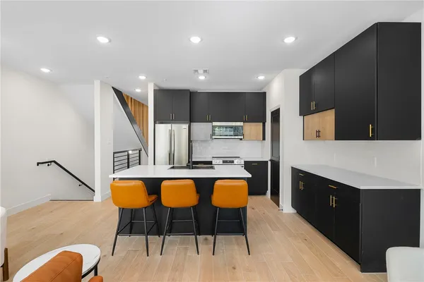 a kitchen with stainless steel appliances kitchen island granite countertop a stove a sink and a refrigerator