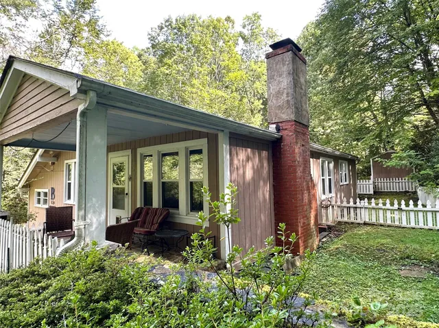a view of a house with a small yard plants and large tree