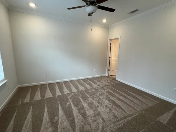 an empty room with closet and a chandelier fan