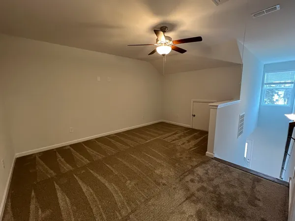 a view of an empty room and wooden floor