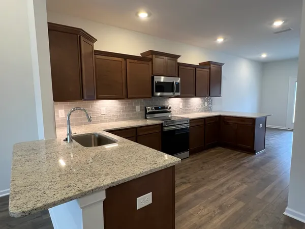 a kitchen with granite countertop a sink cabinets and stainless steel appliances