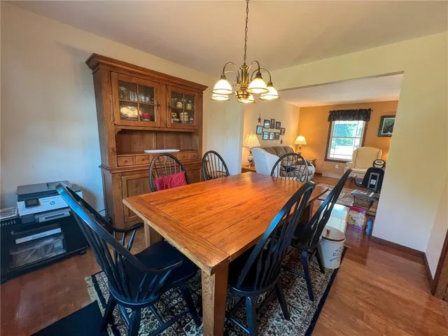 a view of a dining room with furniture a chandelier and wooden floor