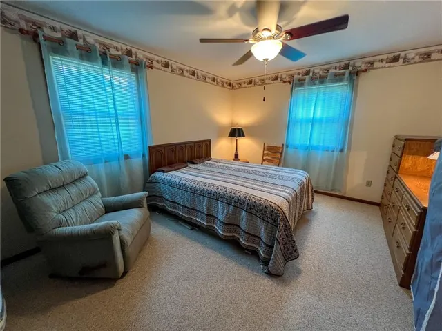 a bedroom with a bed couch and a window