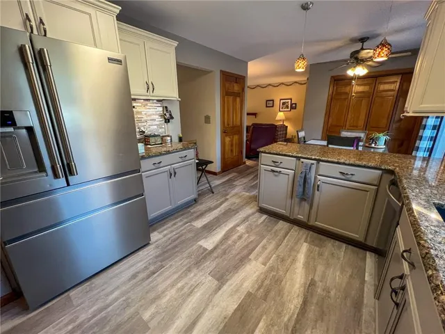 a kitchen with stainless steel appliances granite countertop a refrigerator a stove and a sink