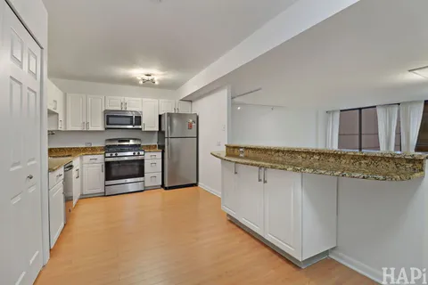 a kitchen with kitchen island a counter top space stainless steel appliances and cabinets