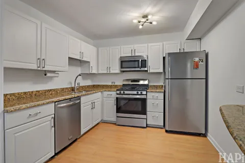 a kitchen with cabinets stainless steel appliances and a counter space