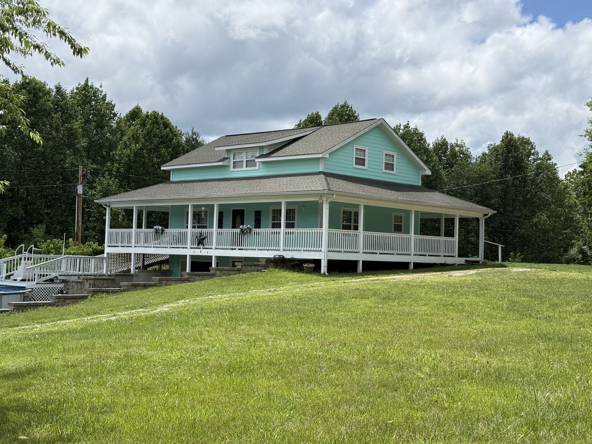 581 Shady Grove Road Bloomington Springs, TN 38545 - Photo 6 of 42 a view of a house with a big yard and large trees