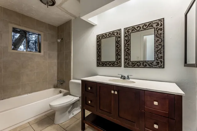 a bathroom with a toilet a sink a tub and a mirror