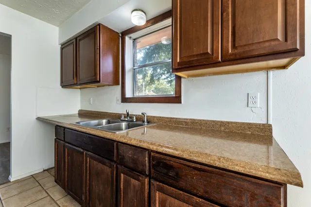 a kitchen with granite countertop stainless steel appliances a sink and a window