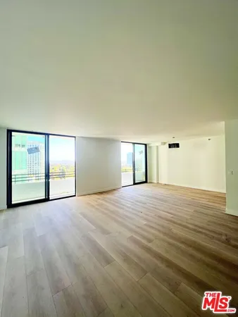 a view of empty room with wooden floor and window