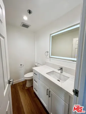 a bathroom with a sink and mirror with toilet