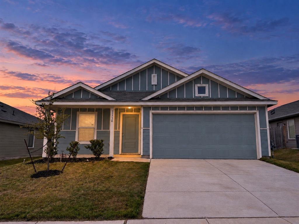 11726 Bone Spg Drive Rhome, TX 76078 - Photo 3 of 29 *Digitally Enhanced* Front exterior at twilight showcasing the home’s inviting covered entry, distinctive blue-and-white exterior, and attached two-car garage.