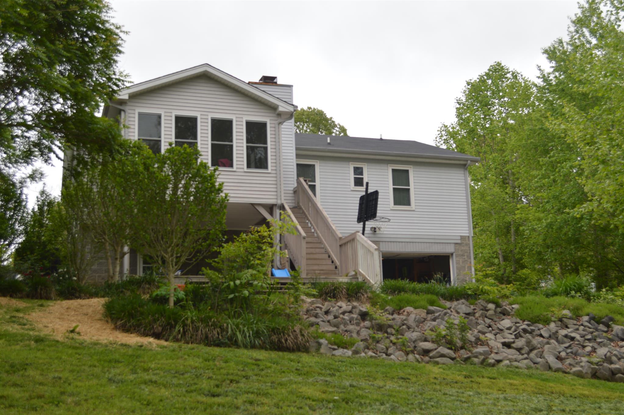 3361 Backridge Road Woodlawn, TN 37191 - Photo 3 of 30 a front view of a house with a garden and plants