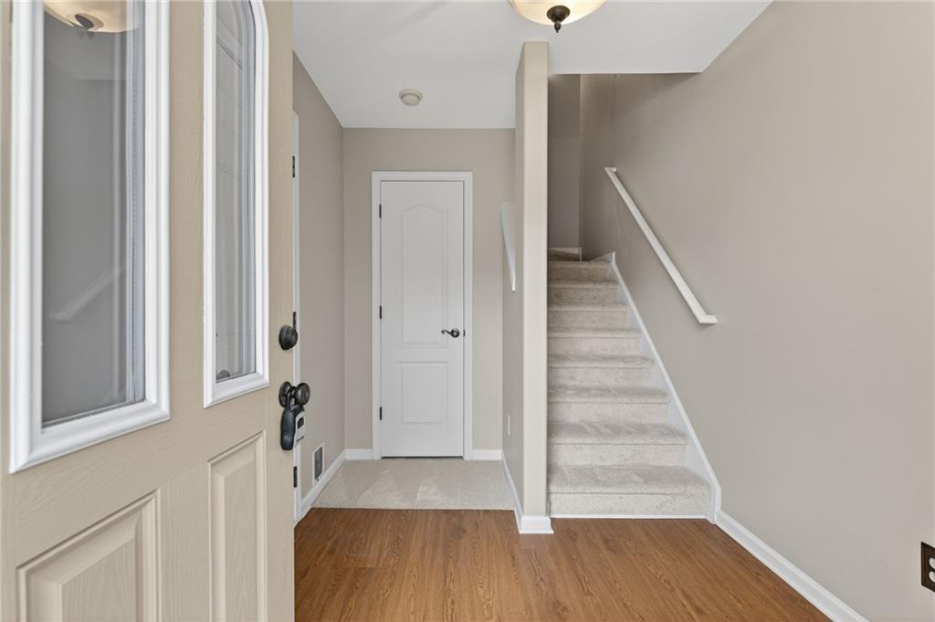 1186 Lake Point Way Suwanee, GA 30024 - Photo 4 of 35 a view of a hallway with wooden floor and staircase