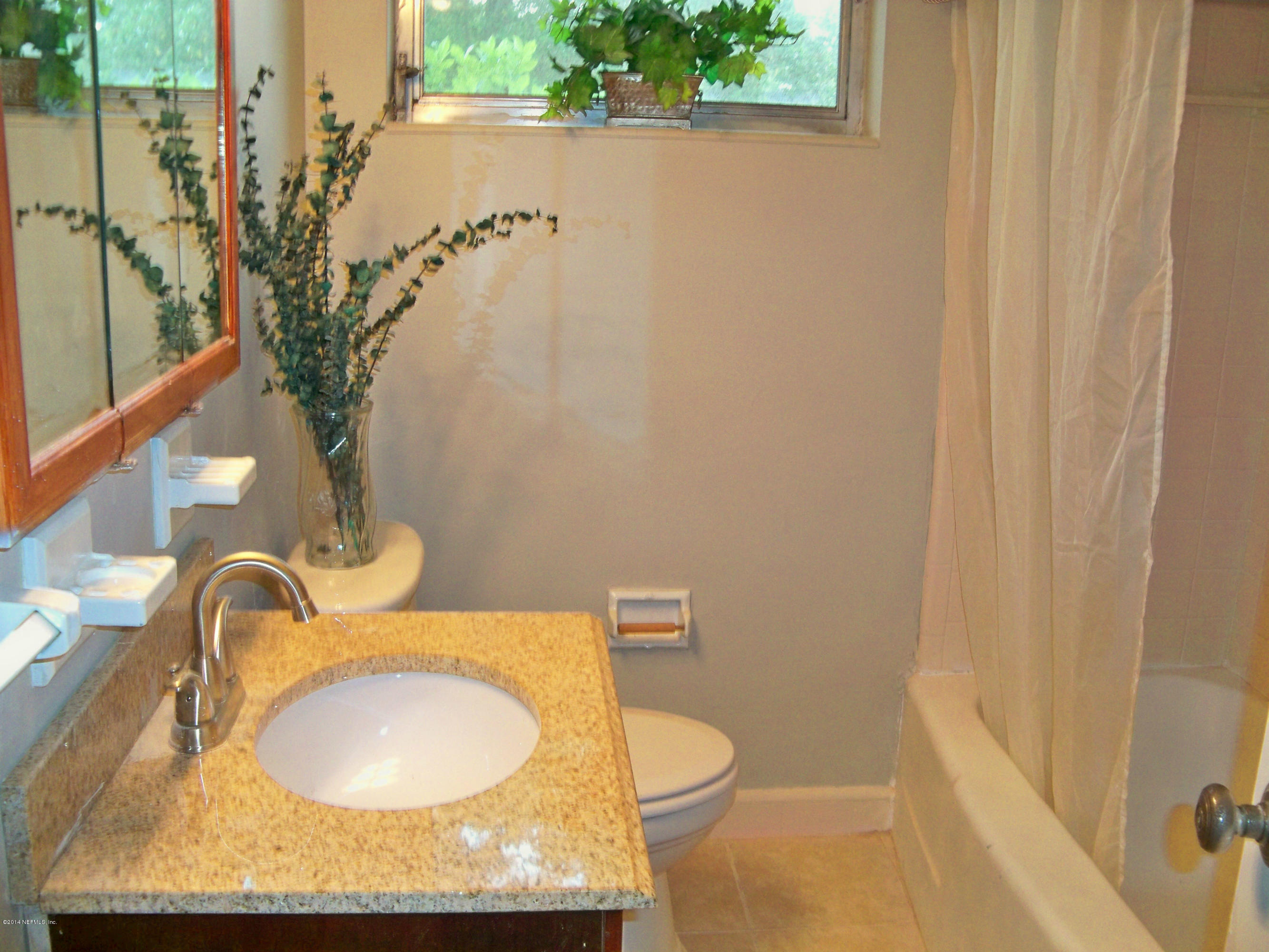 3219 Rogero Road Jacksonville, FL 32277 - Photo 12 of 13 a bathroom with a granite countertop sink and a mirror
