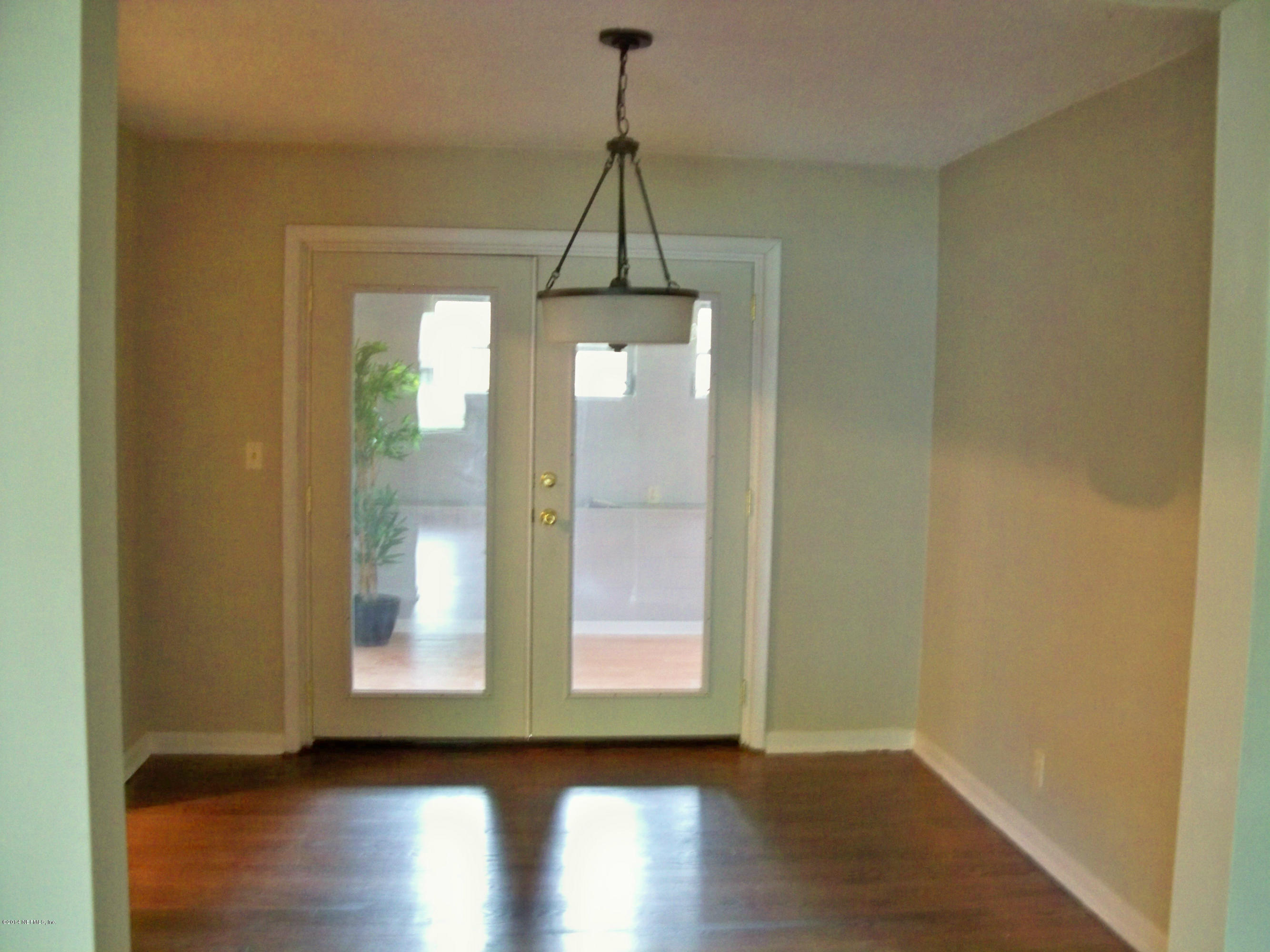 3219 Rogero Road Jacksonville, FL 32277 - Photo 4 of 13 a view of a room with wooden floor and door